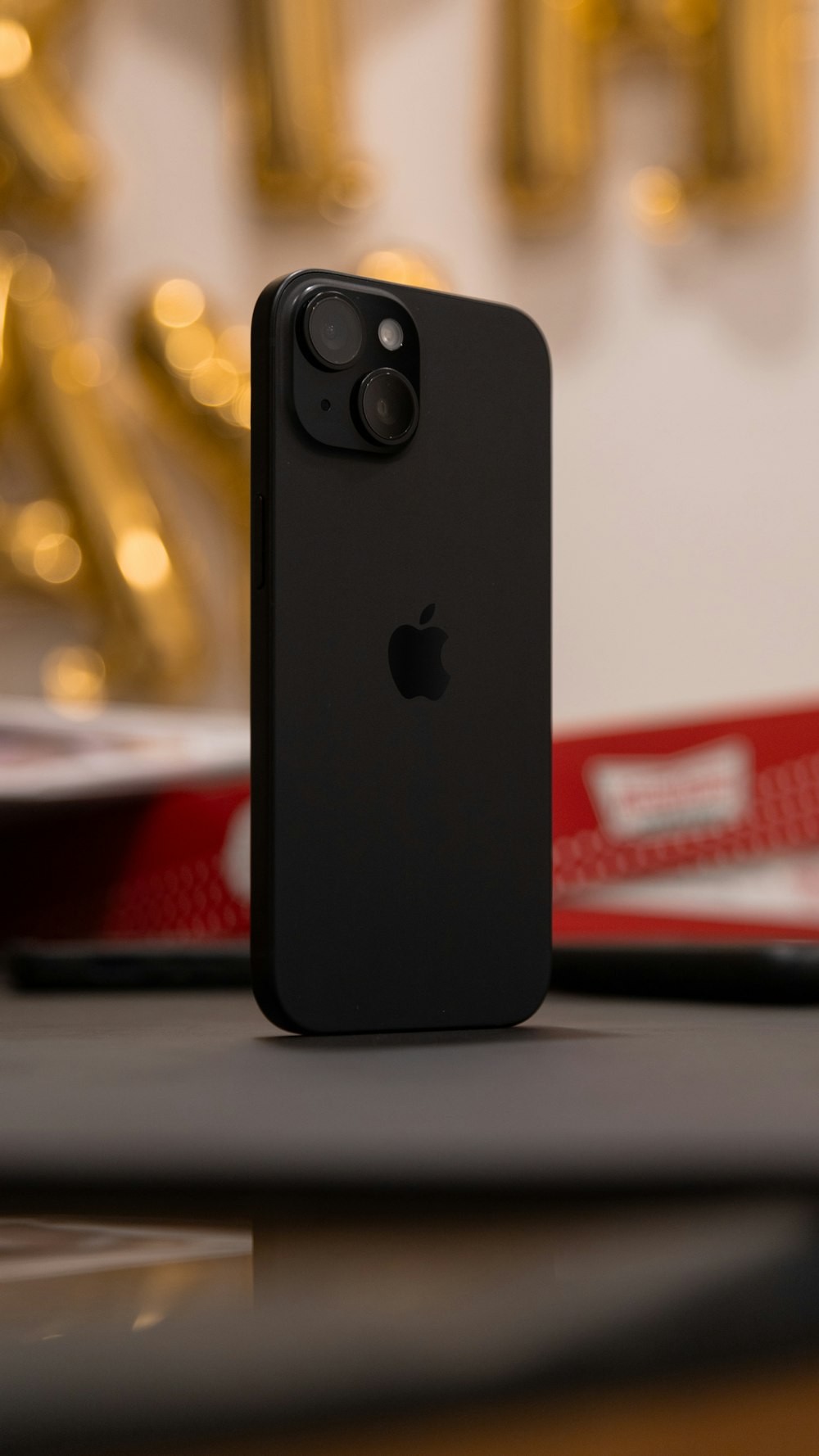 um iphone preto sentado em cima de uma mesa