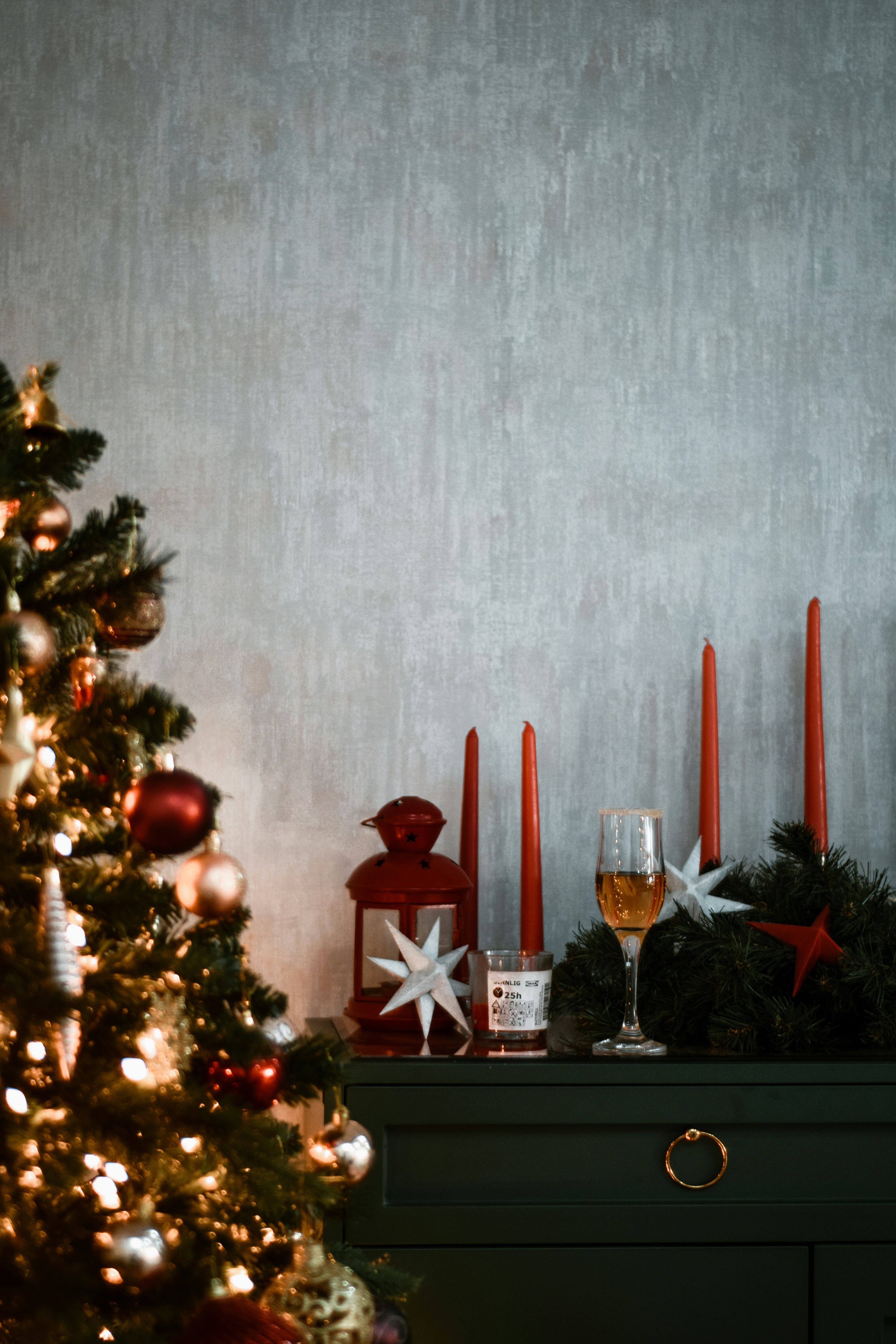 Uma árvore de Natal com velas vermelhas e decorações