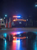 Police officers securing a crime scene at night with flashing blue lights