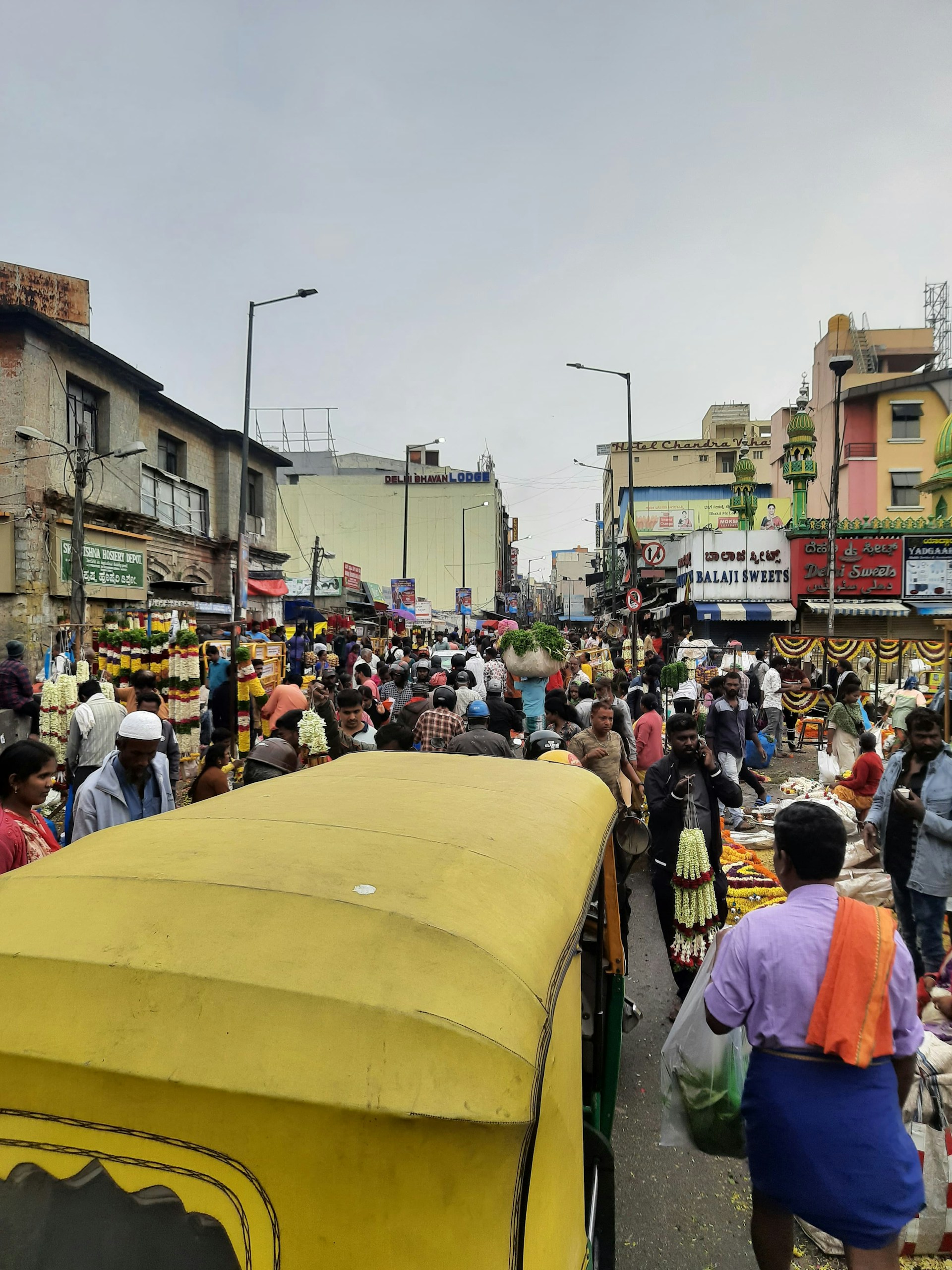 A vibrant street scene in India with colorful markets, spices, and smiling locals under bright sunlight.