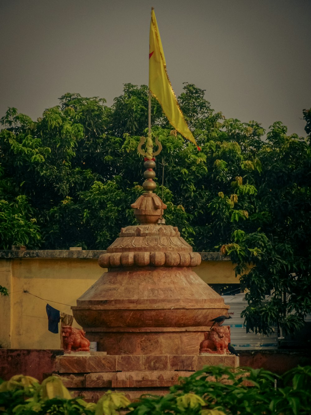 a statue with a yellow flag on top of it