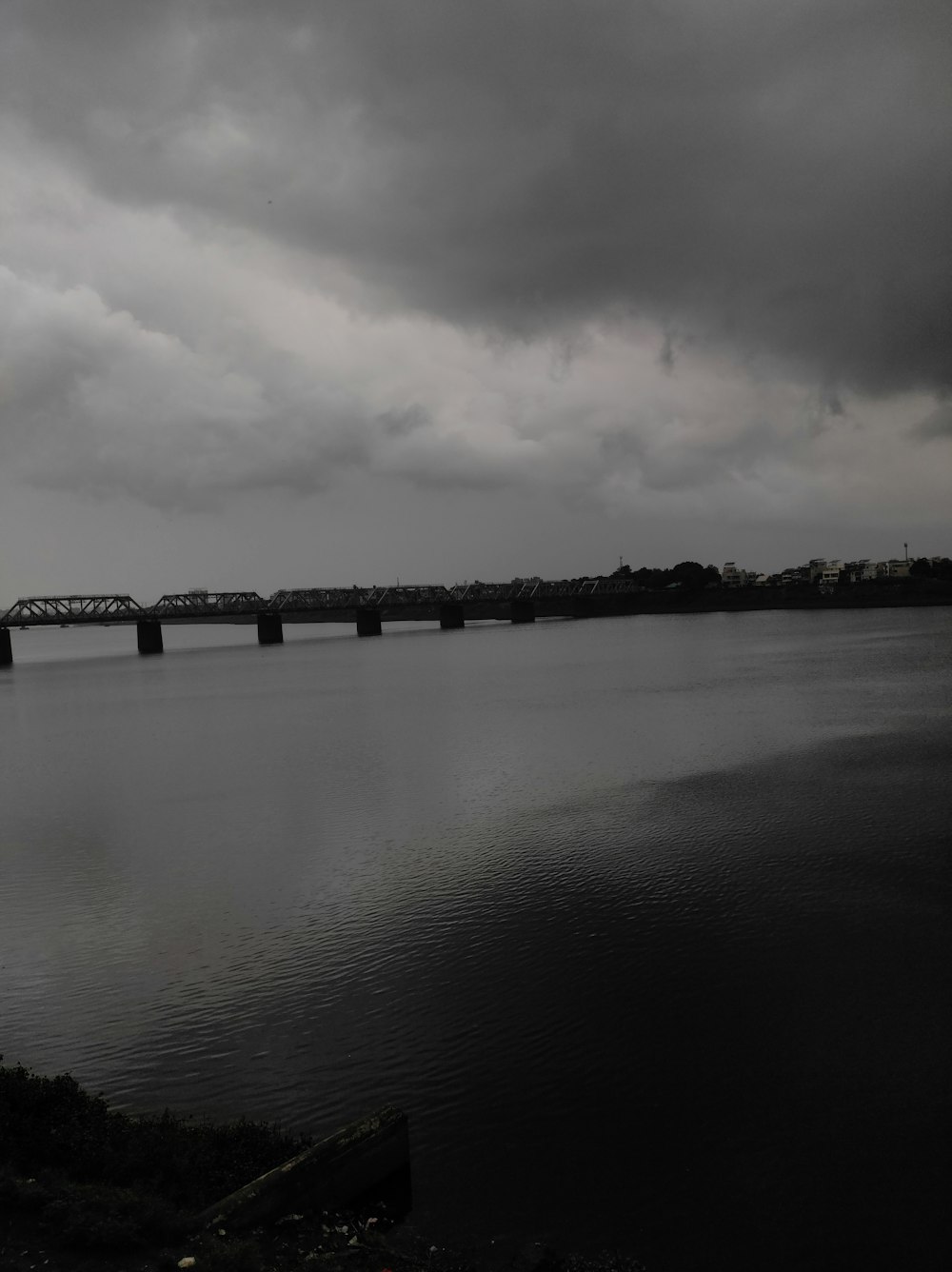 a large body of water with a bridge in the background