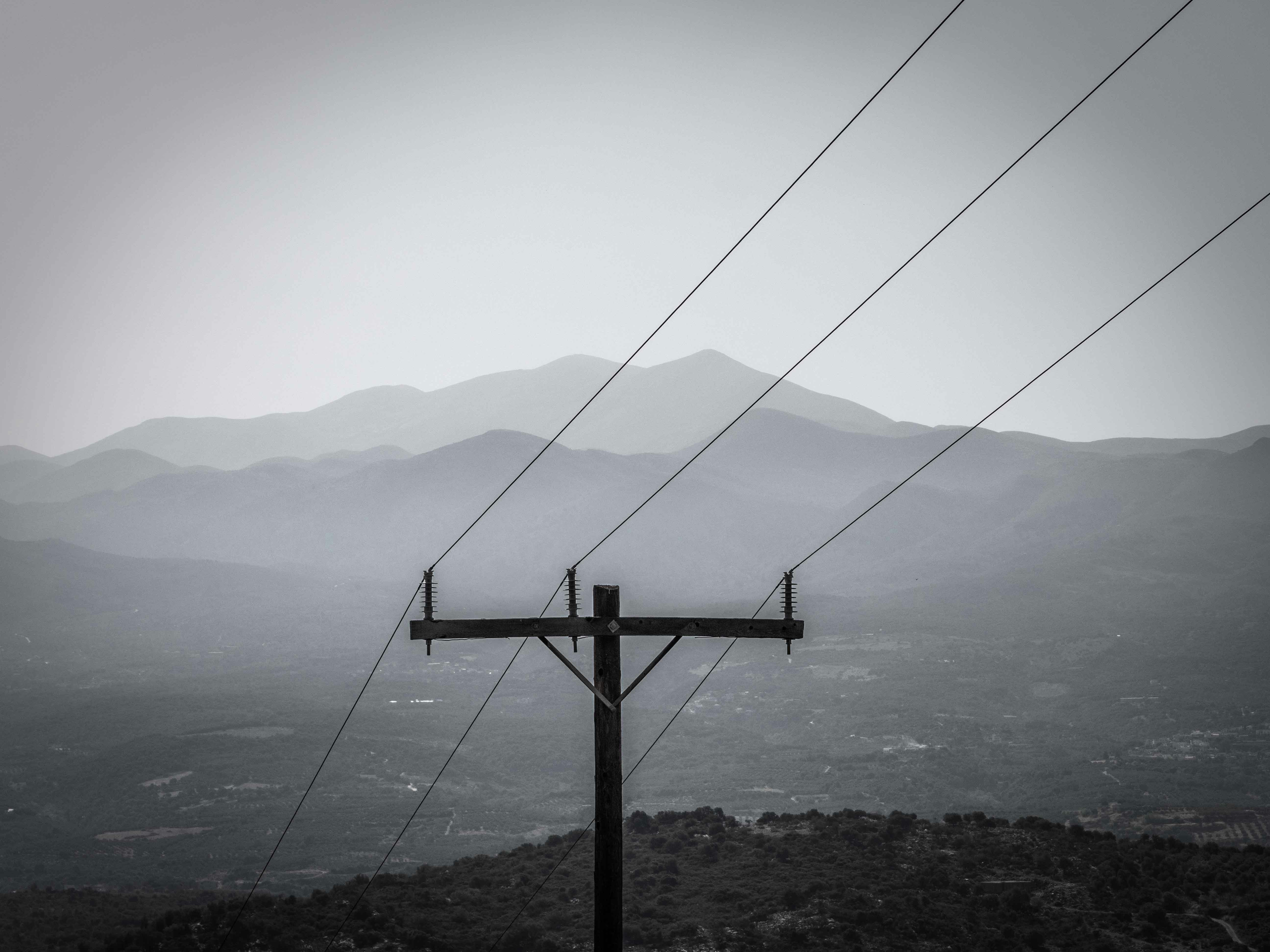 a black and white photo of power lines and mountains