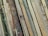 A collection of wooden planks with various textures and colors, ranging from light beige to dark brown, laid out side by side in an overlapping pattern.