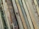 A collection of wooden planks with various textures and colors, ranging from light beige to dark brown, laid out side by side in an overlapping pattern.