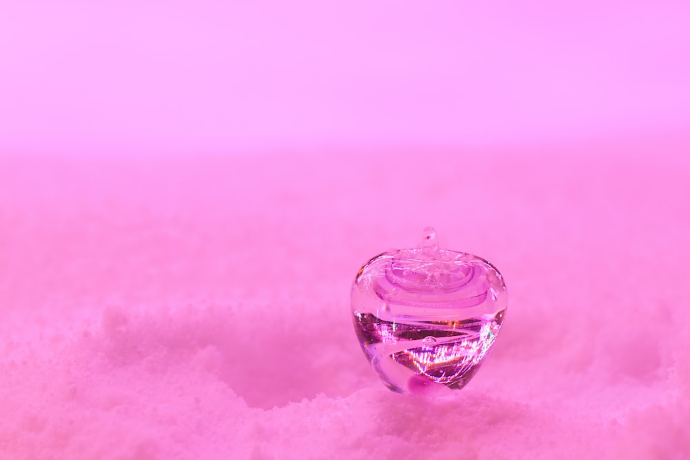 a pink apple sitting on top of a pile of snow