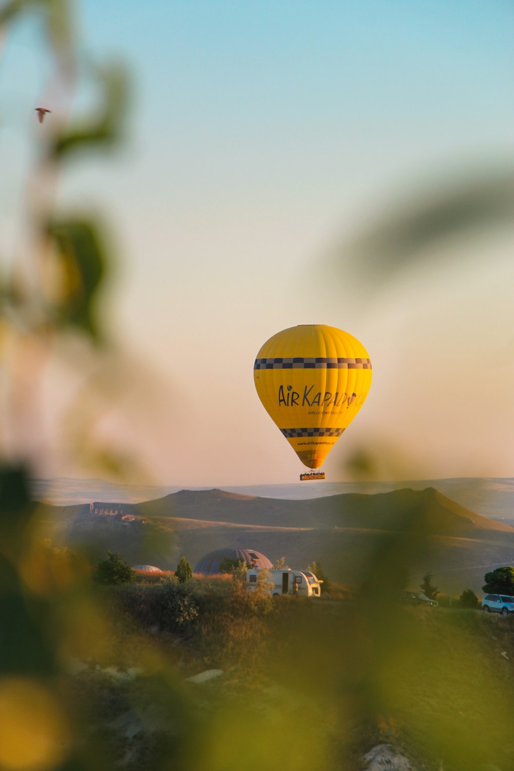 a yellow hot air balloon flying through a blue sky