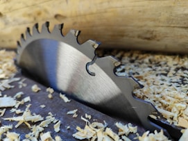 a close up of a metal blade on a piece of wood