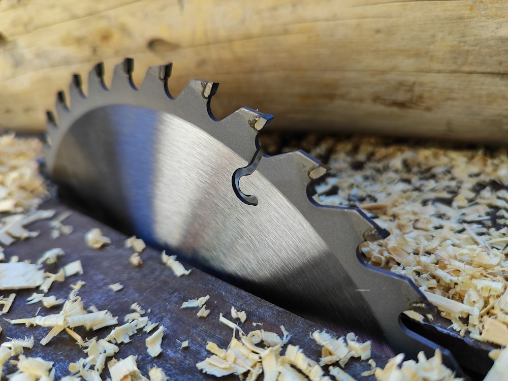 a close up of a metal blade on a piece of wood