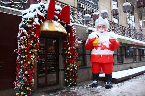 a statue of a man dressed as santa claus in front of a store