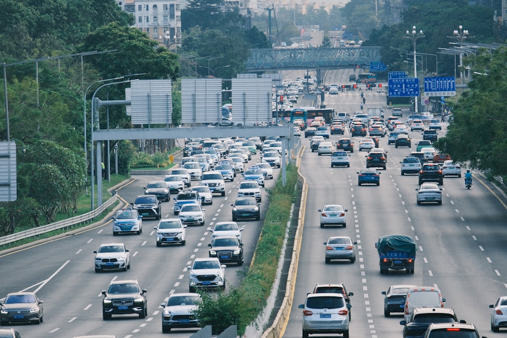 a highway filled with lots of traffic next to tall buildings