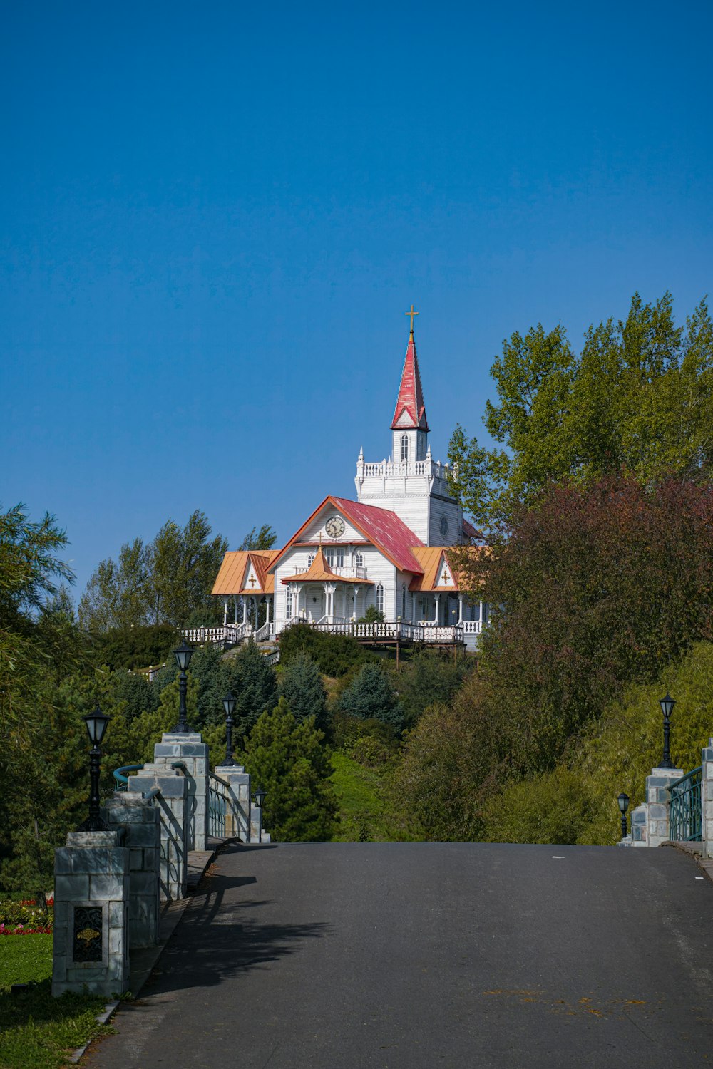 a white church with a red roof on top of a hill