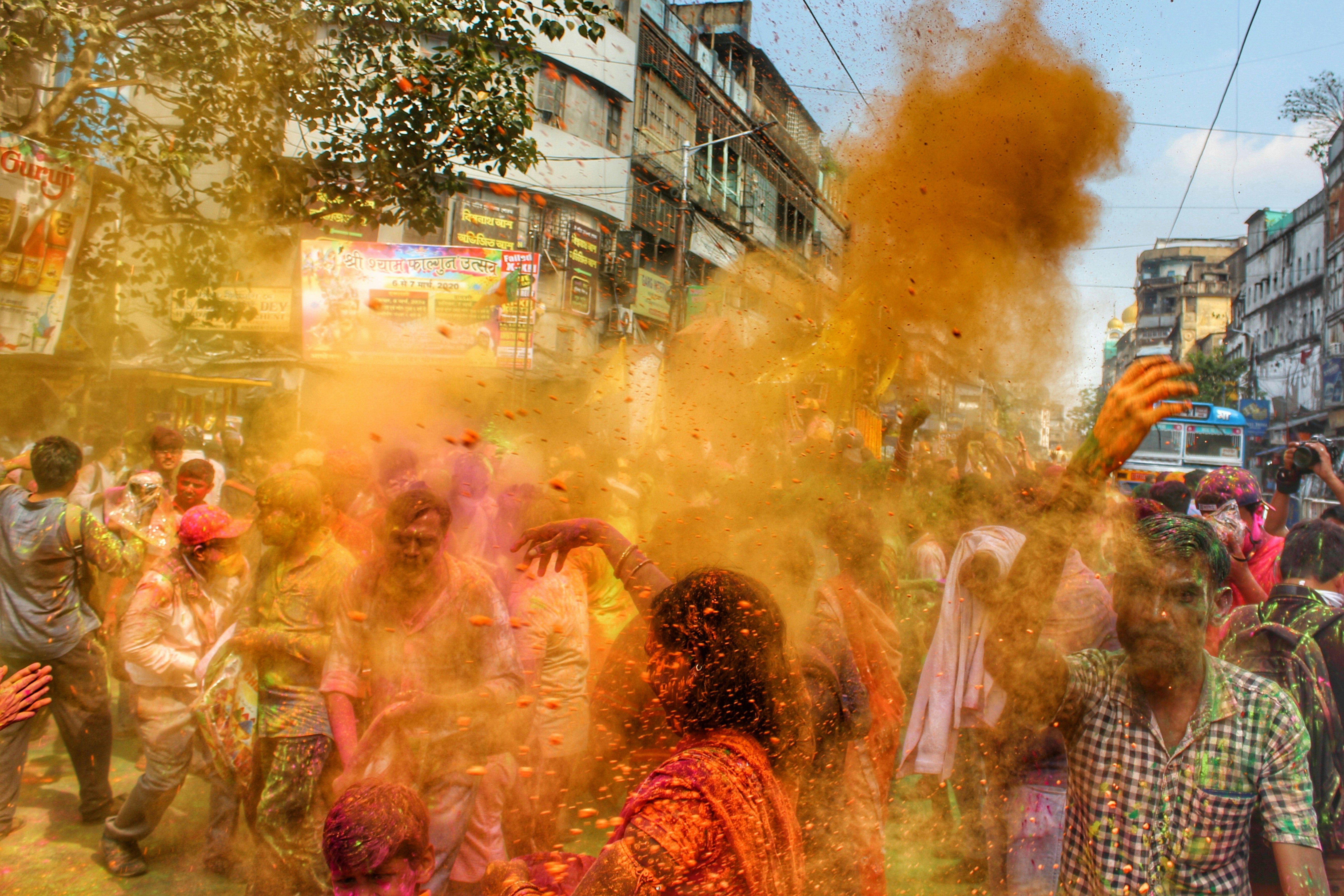 a group of people are throwing colored powder on each other