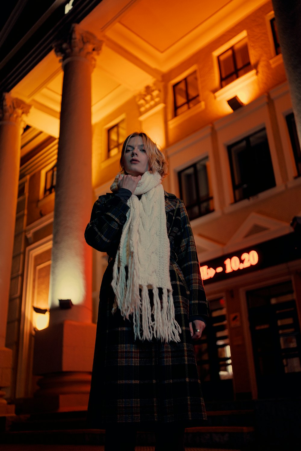 a woman standing in front of a building at night