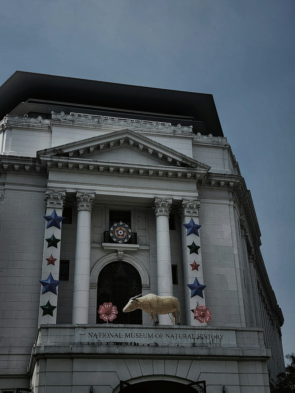 ein großes Gebäude mit der Statue eines Pferdes auf der Spitze