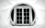 Wide shot of a luxury villa entrance featuring dimansi doorbell with cinematic lighting and snowfall effect
