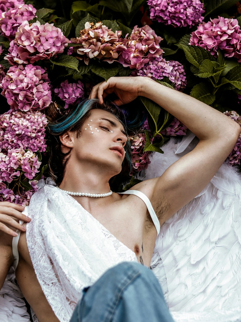 a woman laying on the ground next to a bunch of flowers
