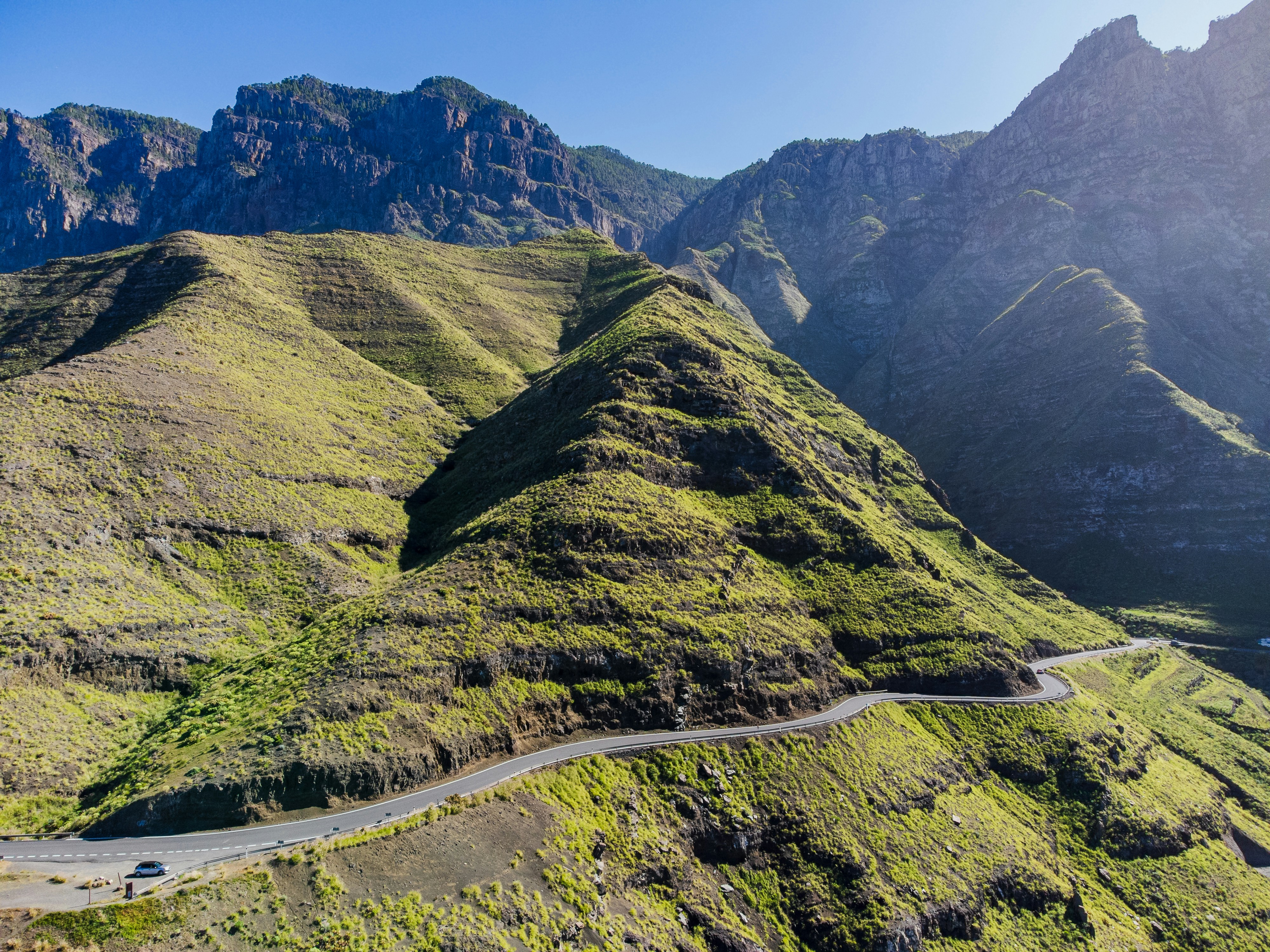 a car driving down a winding road in the mountains