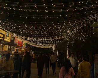 A lively street scene in Singapore at night, showcasing colorful lights and happy tourists.