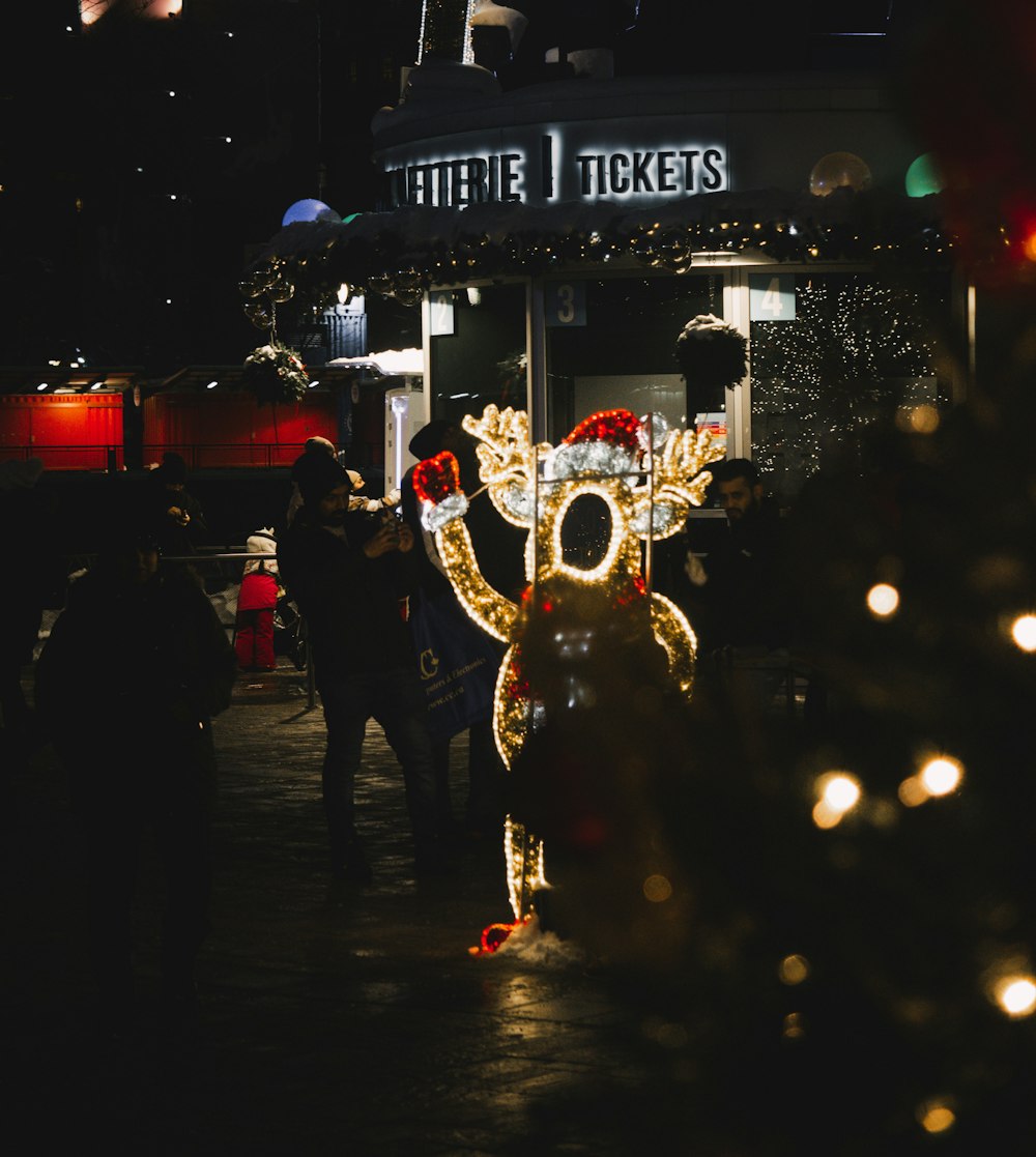 a lighted reindeer in front of a ticket booth