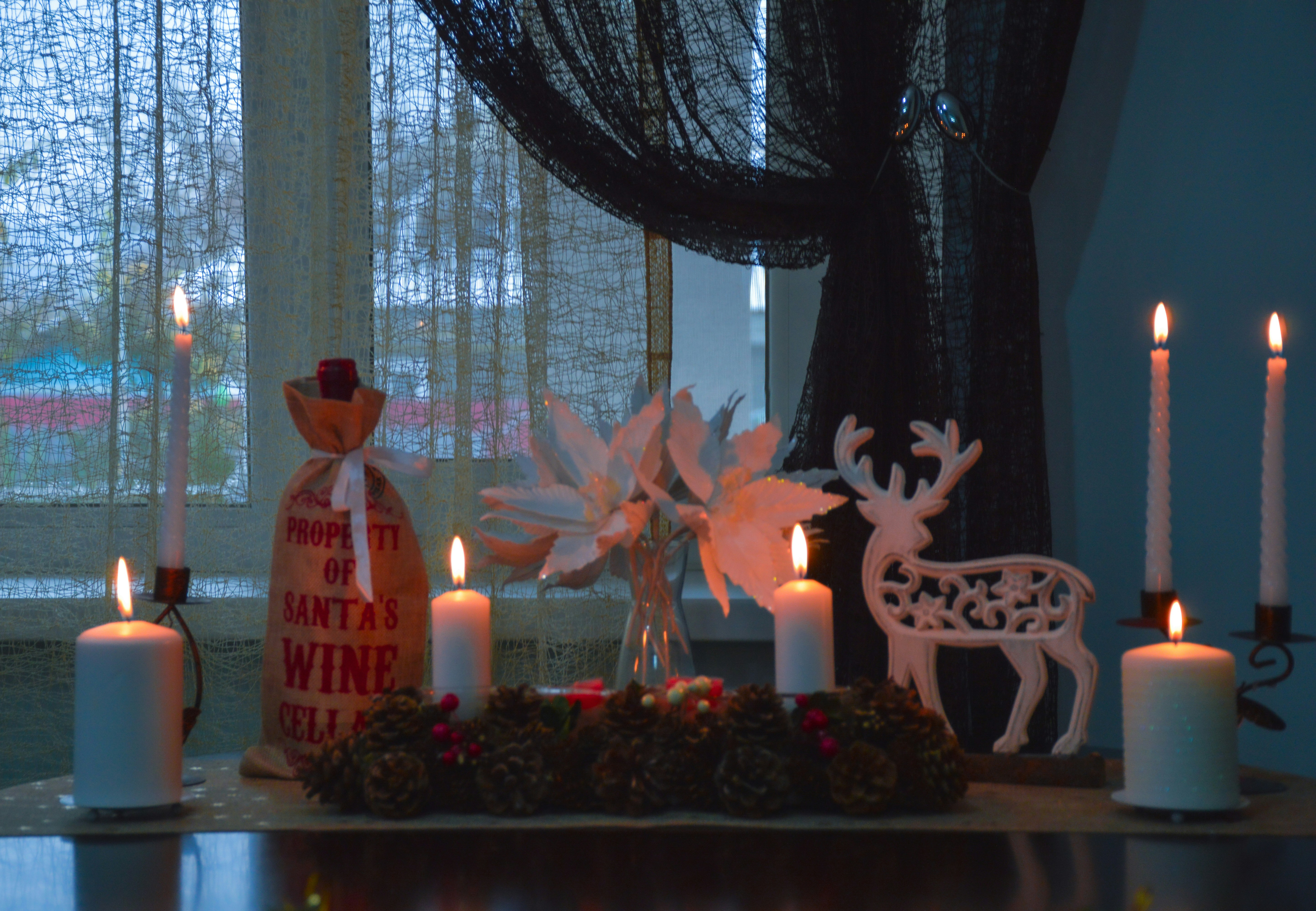 a table topped with candles and christmas decorations