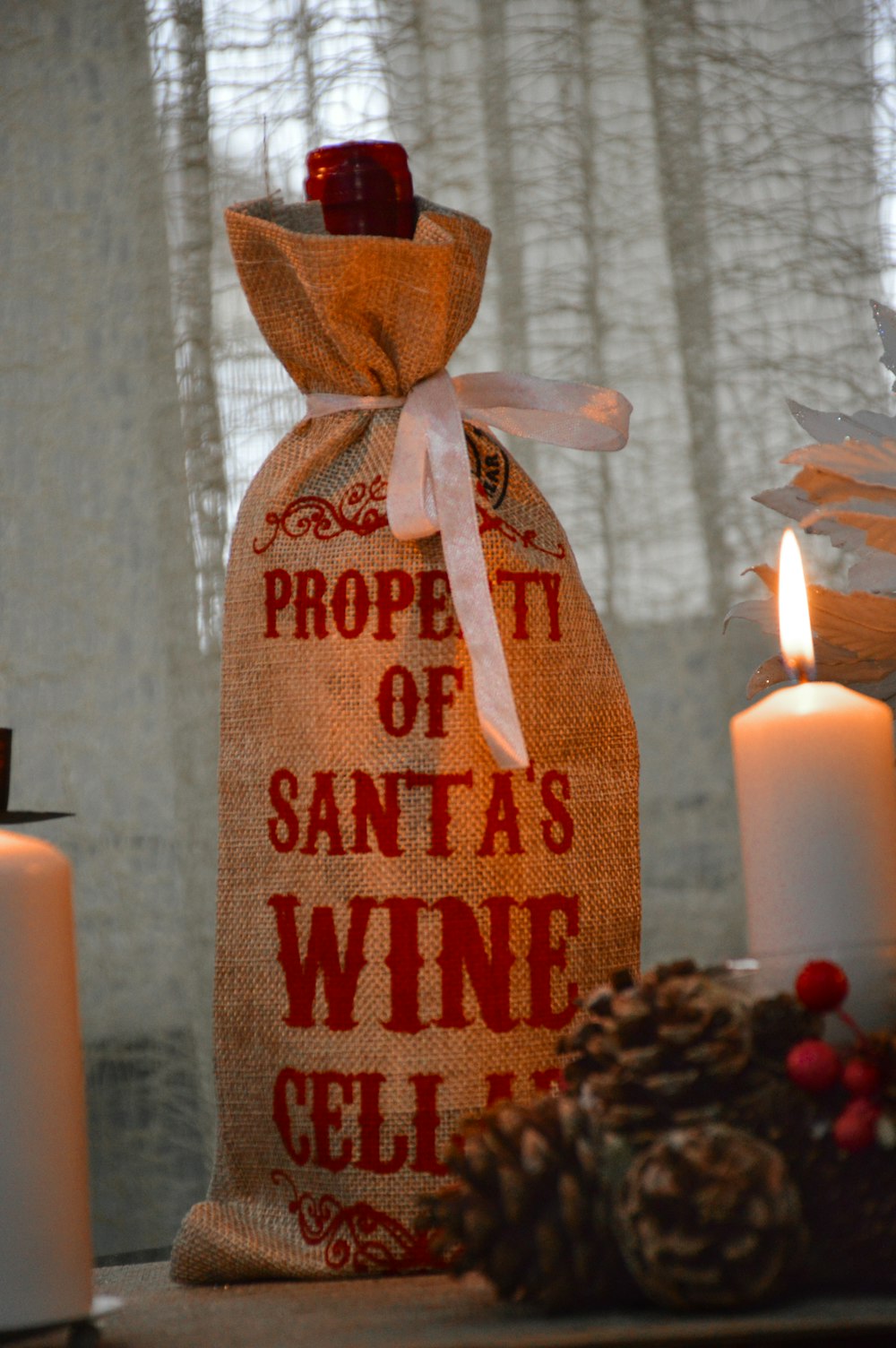a bag of wine sitting on a table next to candles