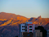 Sunset over the Núcleo Áureo complex, casting warm light on the rugged landscape.