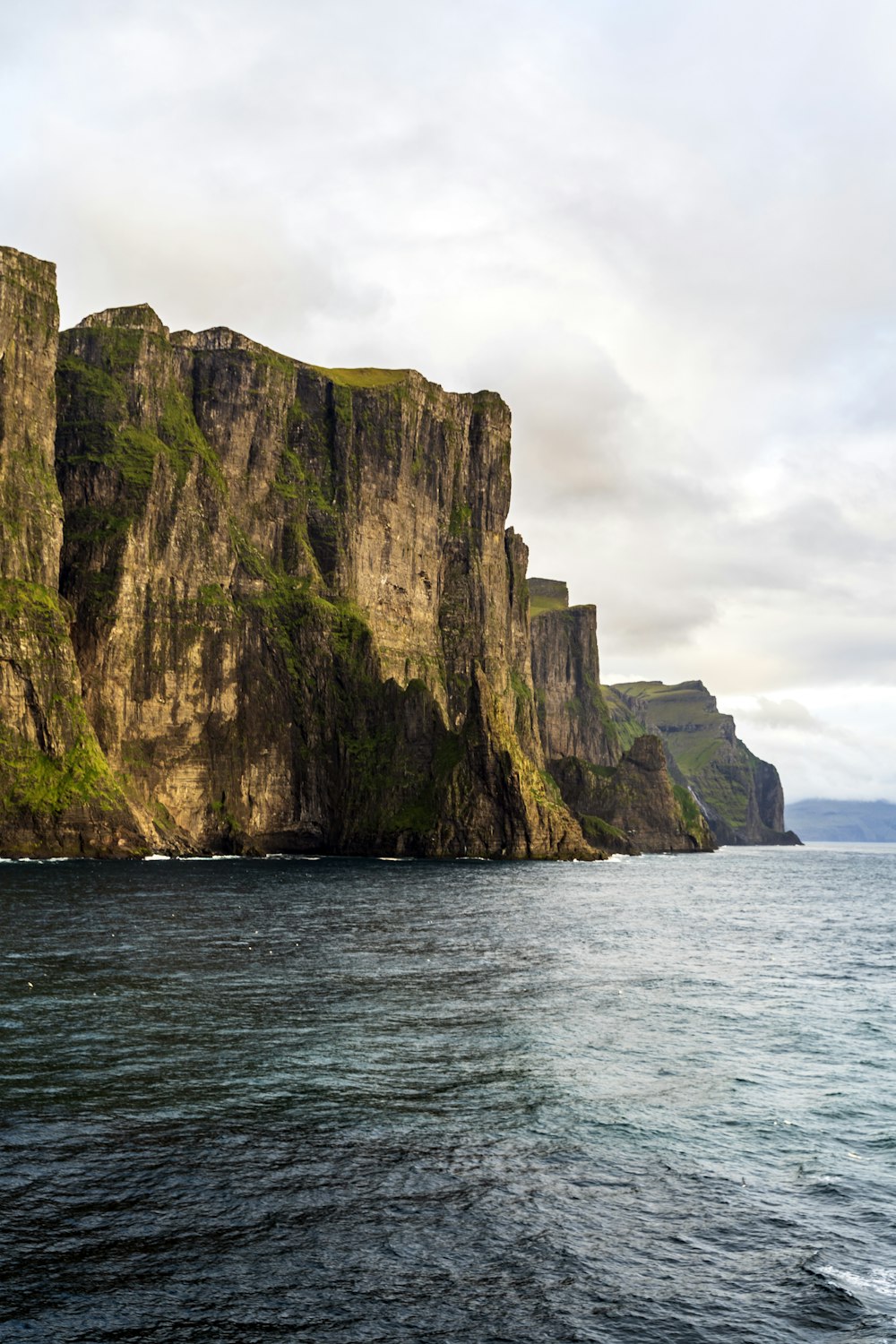 a large body of water with a mountain in the background