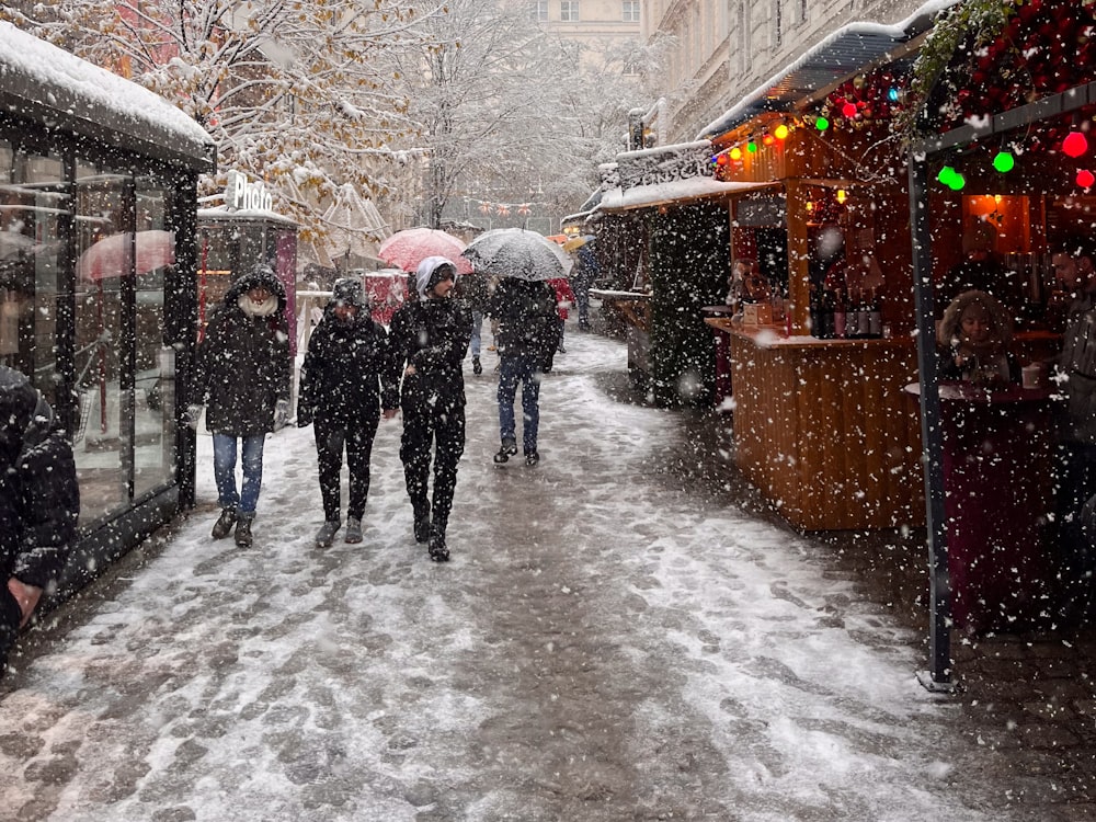 a group of people walking down a snow covered street