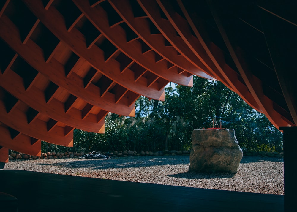 a large rock sitting under a red structure