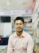 Customer smiling while trying on new glasses in a bright optical store.