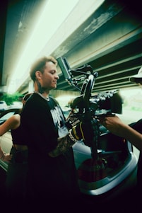 a man standing next to a car holding a camera