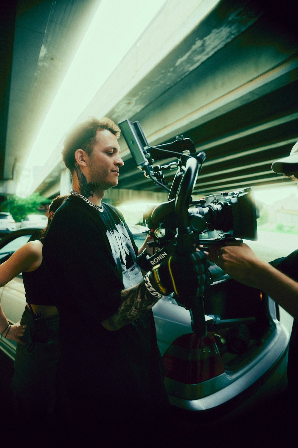 a man standing next to a car holding a camera