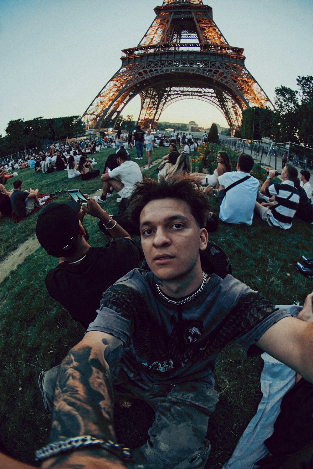 a man sitting on the ground in front of the eiffel tower