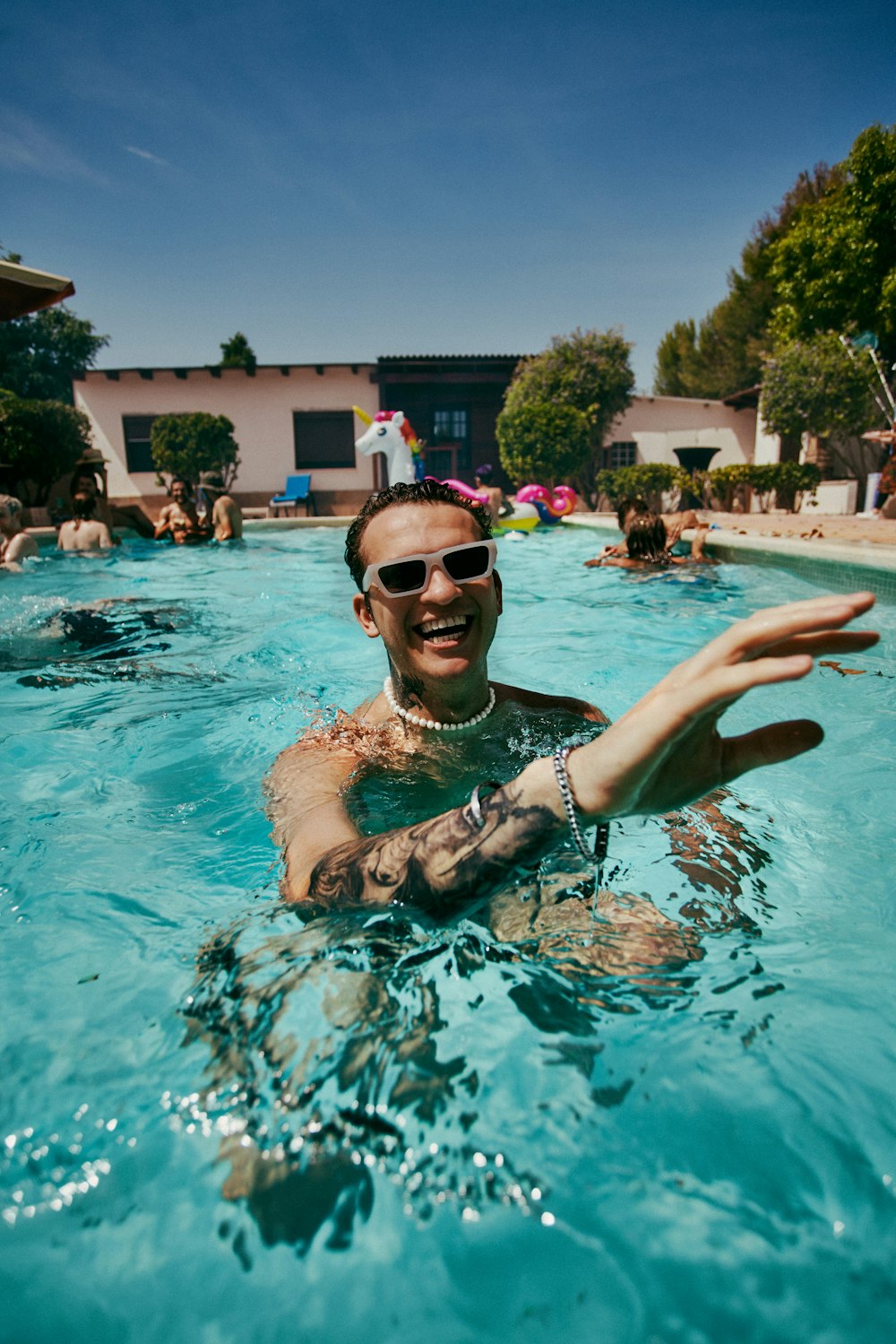 a man swimming in a pool with people in the background