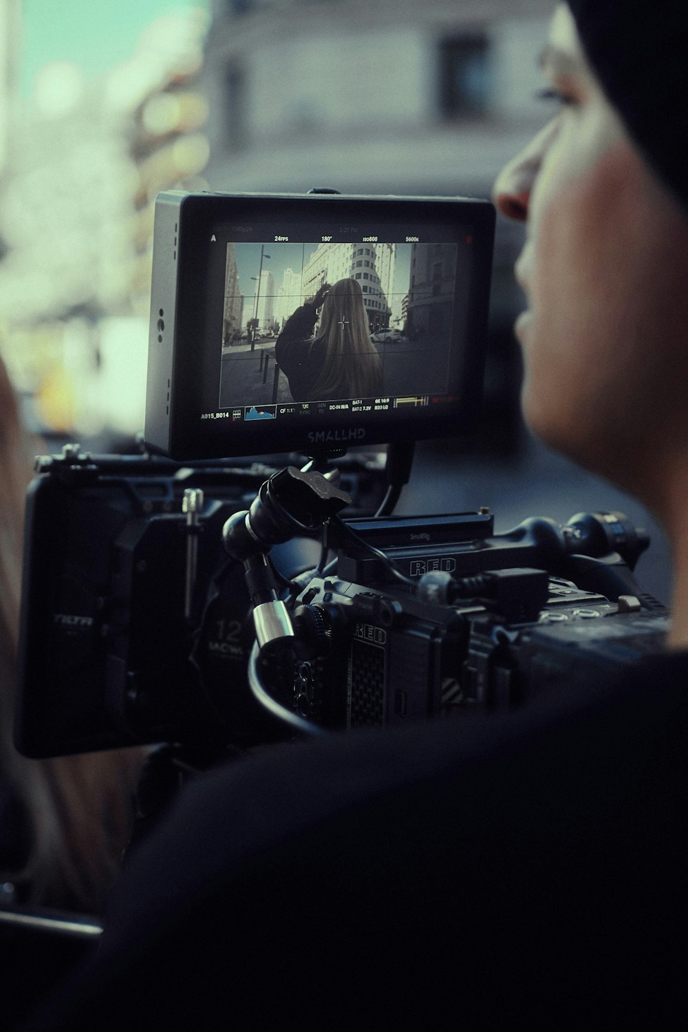 a woman holding a video camera in front of a man