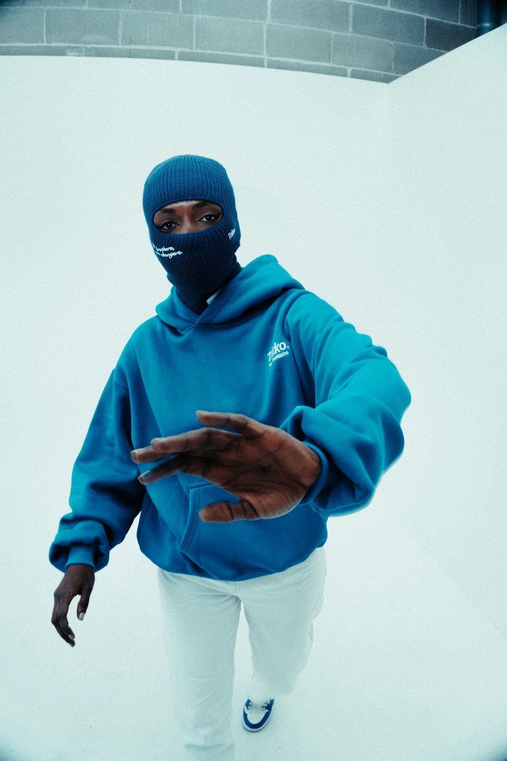 a man wearing a blue hoodie and a face mask