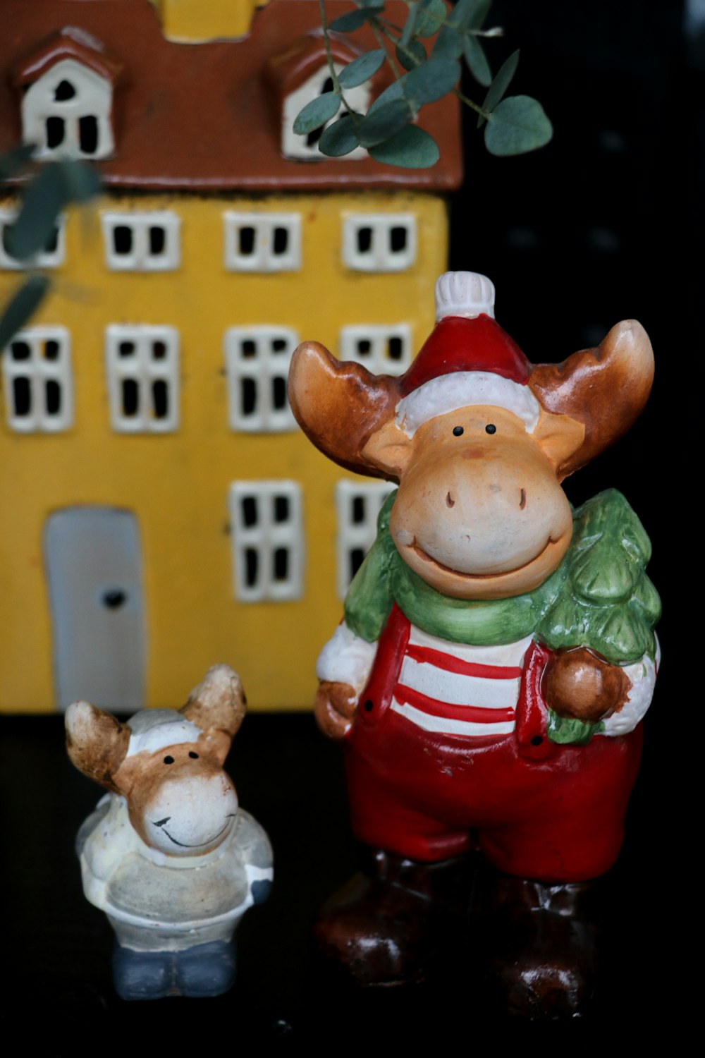 a ceramic cow and a small cow figurine on a table