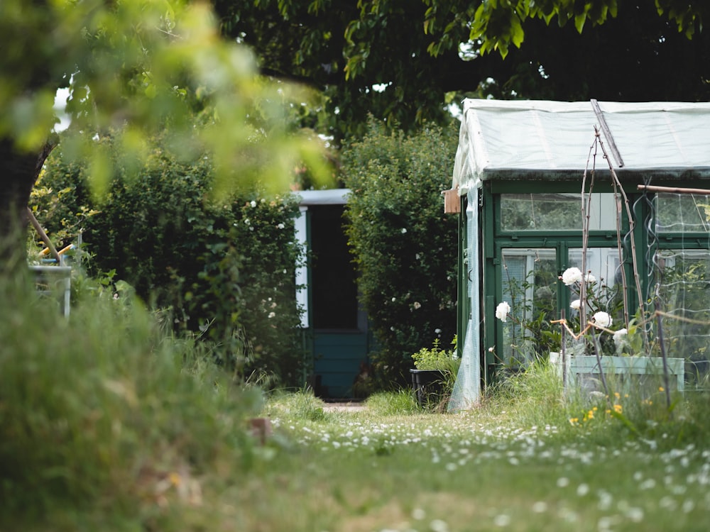 a small green house with a white roof