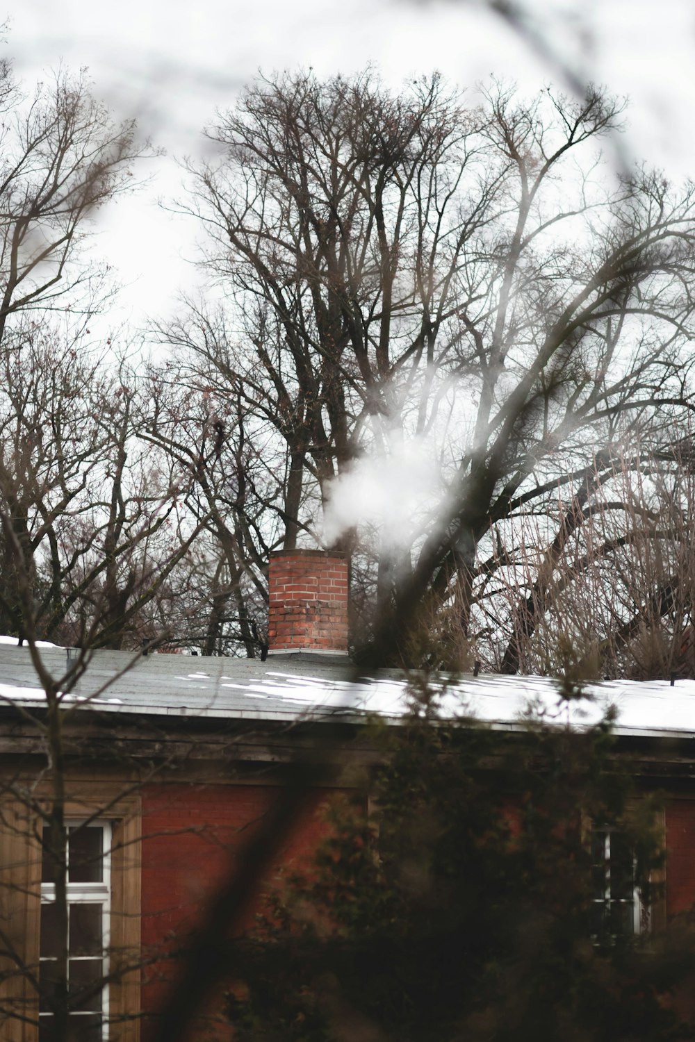 a red brick building surrounded by trees covered in snow