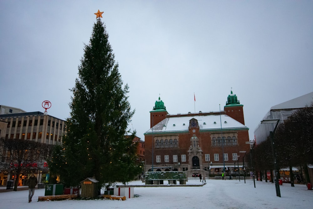 Un grand bâtiment avec un sapin de Noël devant