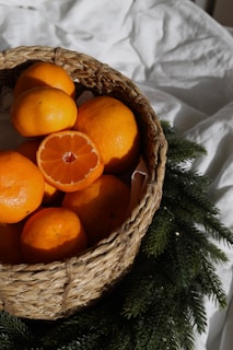 A close-up of ripe oranges and lemons in a woven basket.