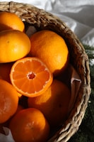 Close-up of bright orange Satsuma mandarins with a rustic wooden crate in the background.