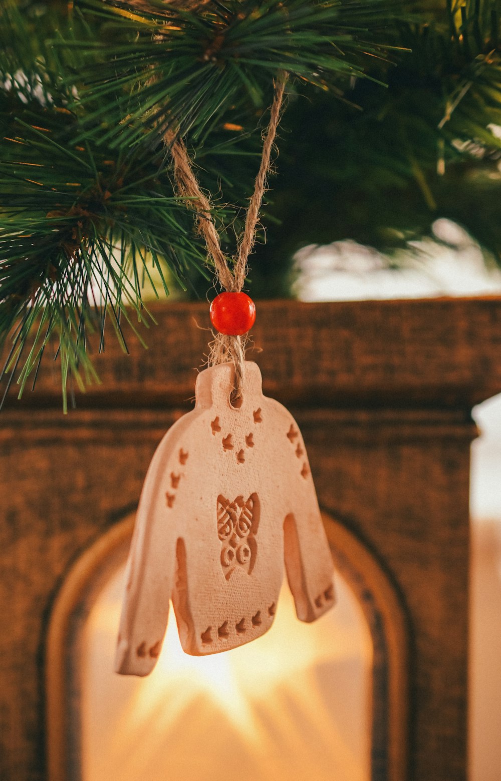 a ceramic ornament hanging from a christmas tree