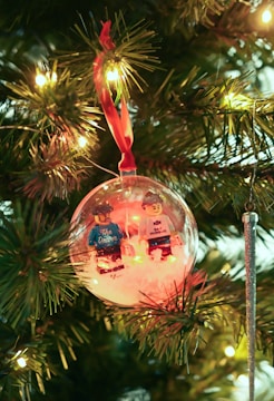 Festive Lego Christmas ornaments hanging on a decorated tree.