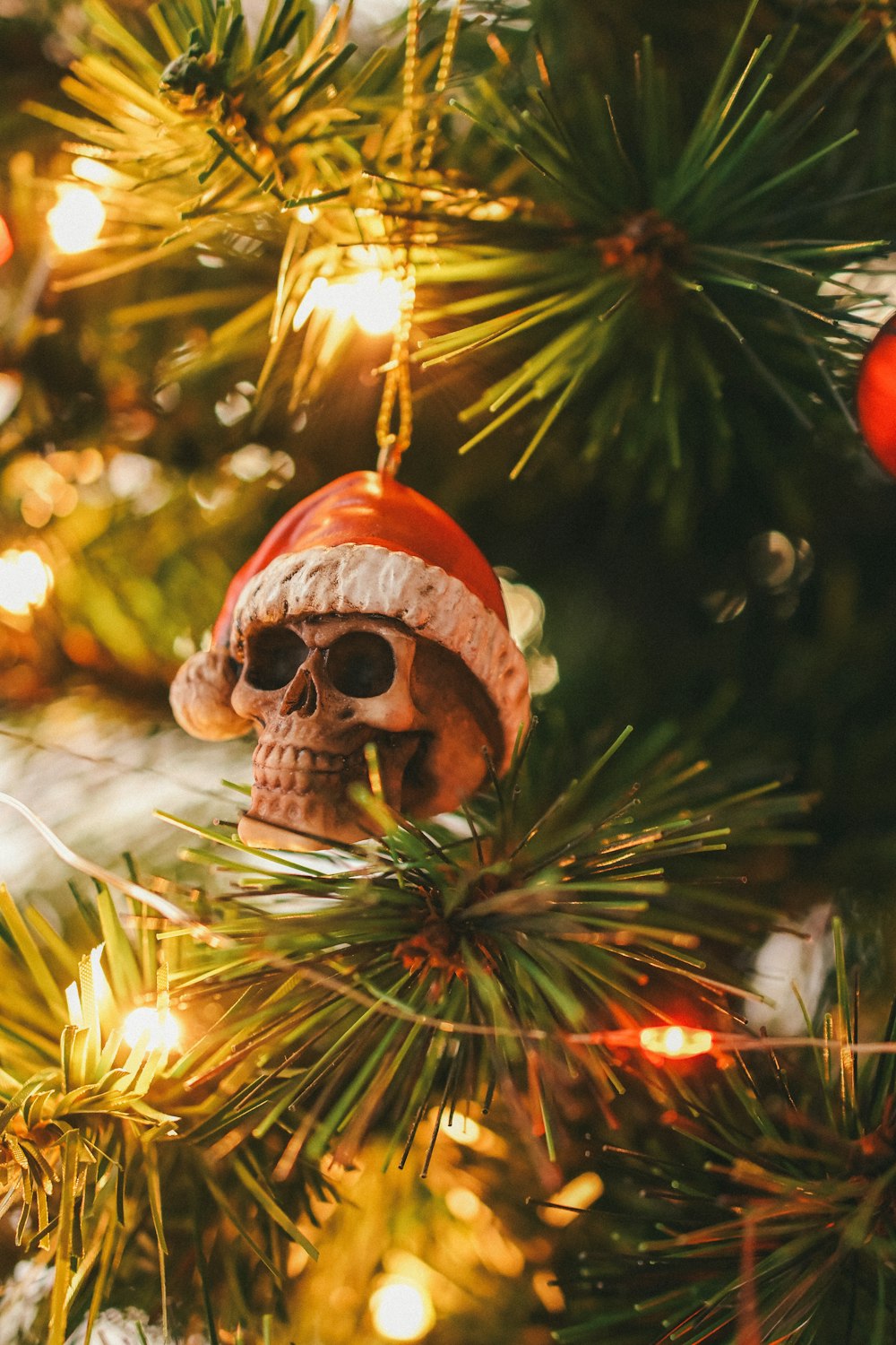 a skull ornament hanging from a christmas tree