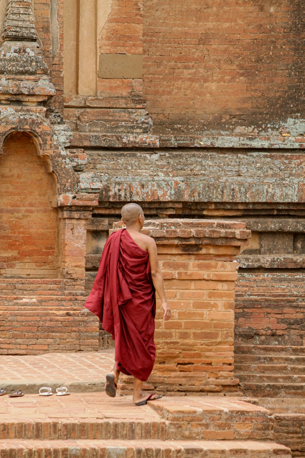 a man in a red robe walking up some steps