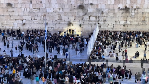 A gathering of community members praying at a historic site.