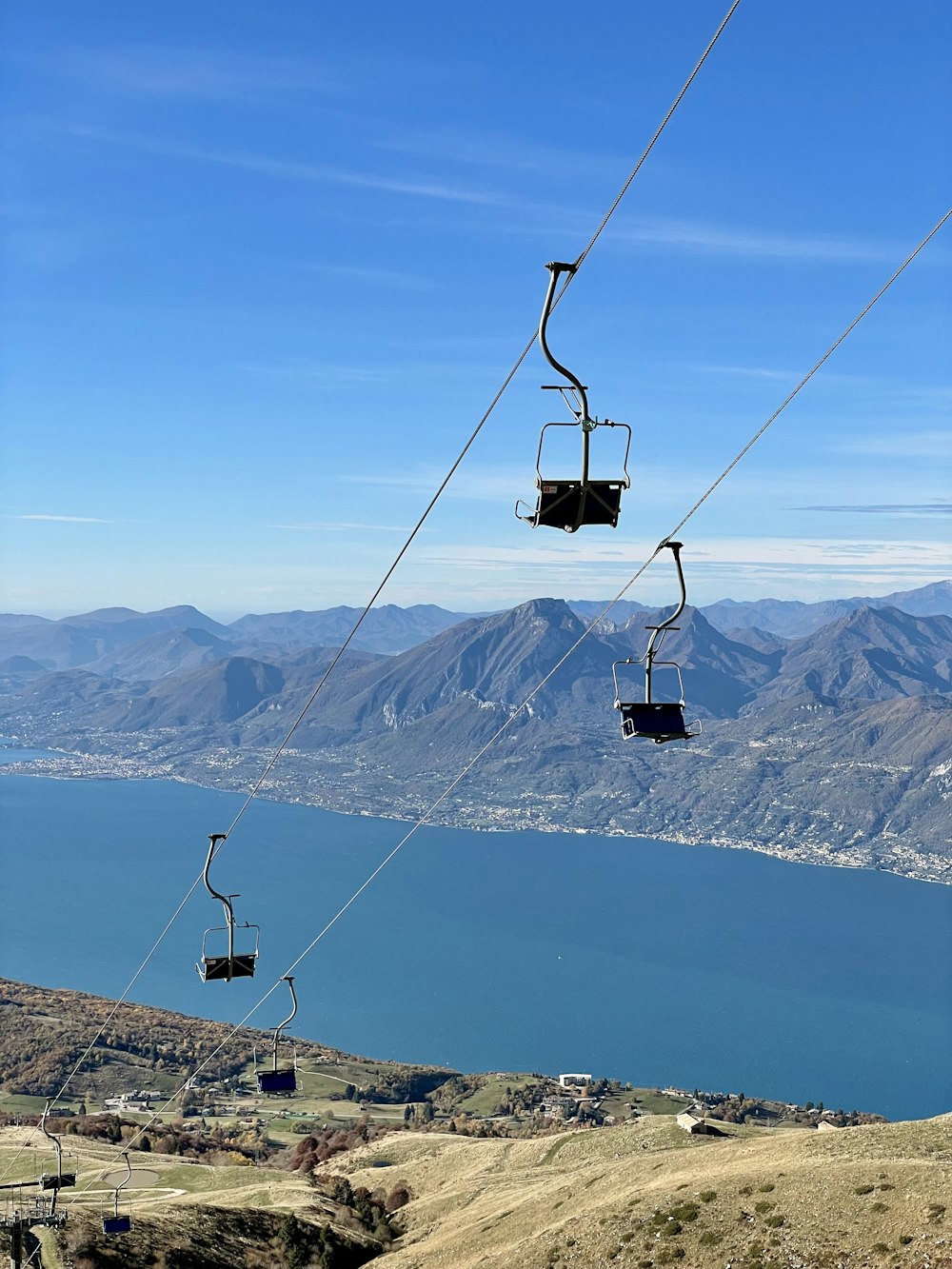 a couple of gondolas hanging from a wire above a body of water