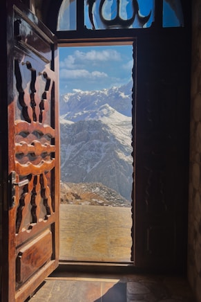 an open door with a view of a mountain range